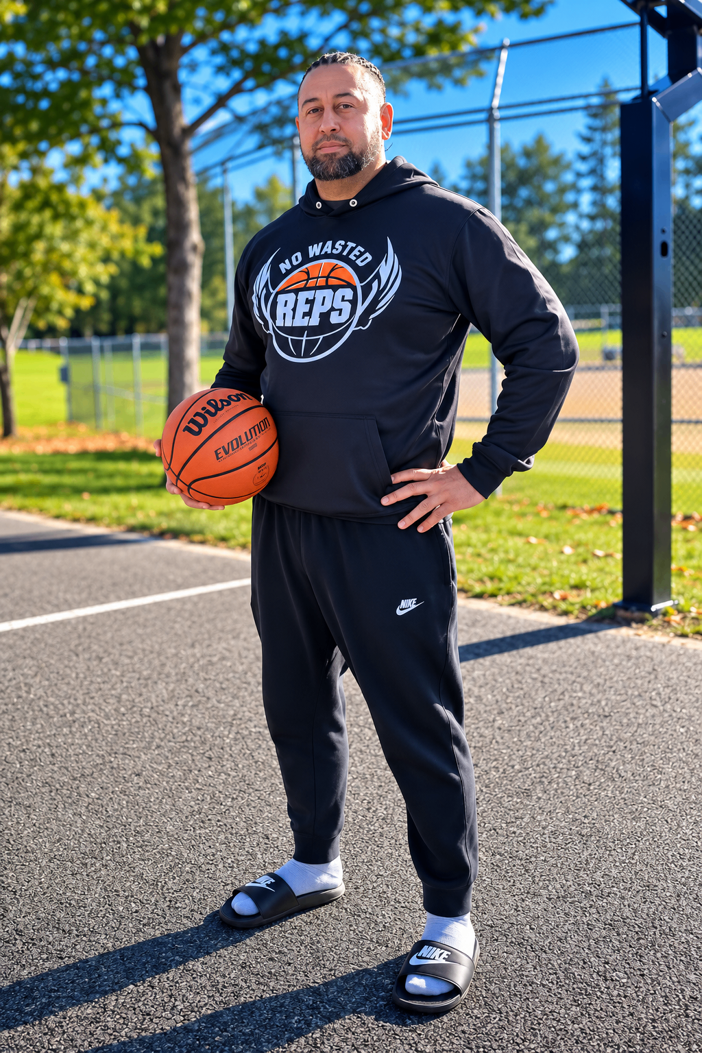 Coach Kenny Stanley holding a basketball at an outdoor court